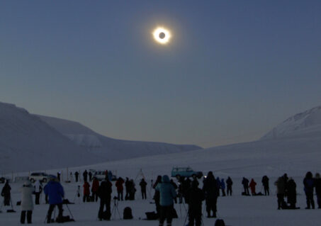 In the snow on Svalbard, TQ travelers admire an Arctic totality. The top image is the pre-eclipse scene, also on Svalbard. (Photo by Jay Anderson)