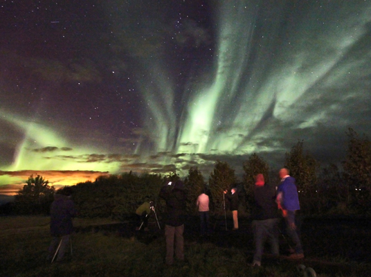 TravelQuest aurora chasers viewing and photographing an aurora from our countryside hotel. (Photo by Paul Deans/TQ)